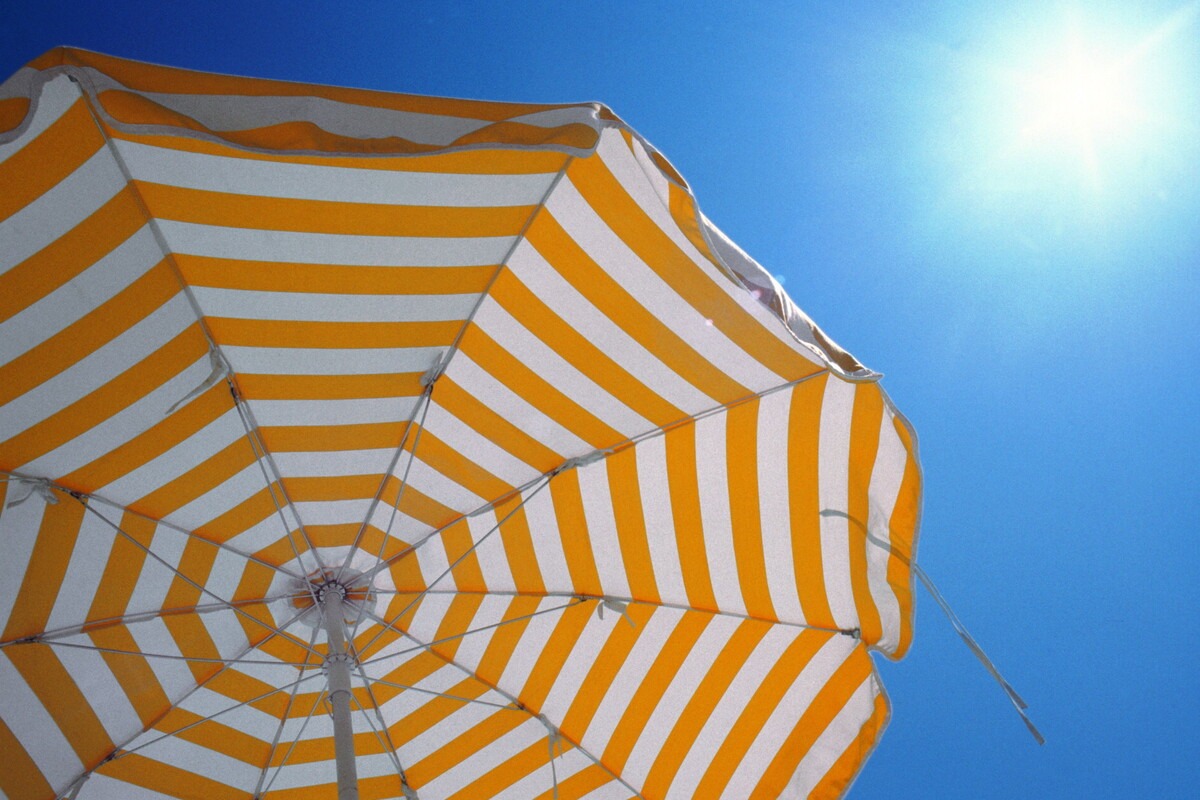 Oranje parasol met blauwe zomerse lucht