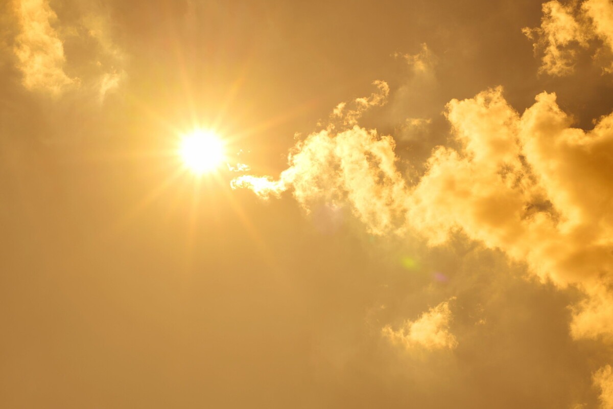 Lucht met wolken en een felle zon