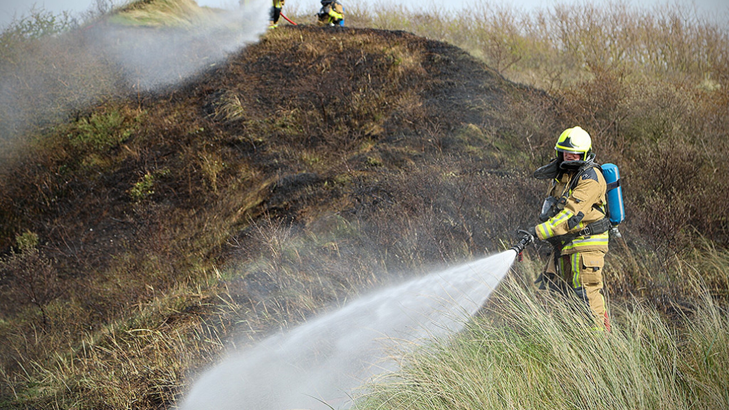 Brandweer blust brand in de duinen