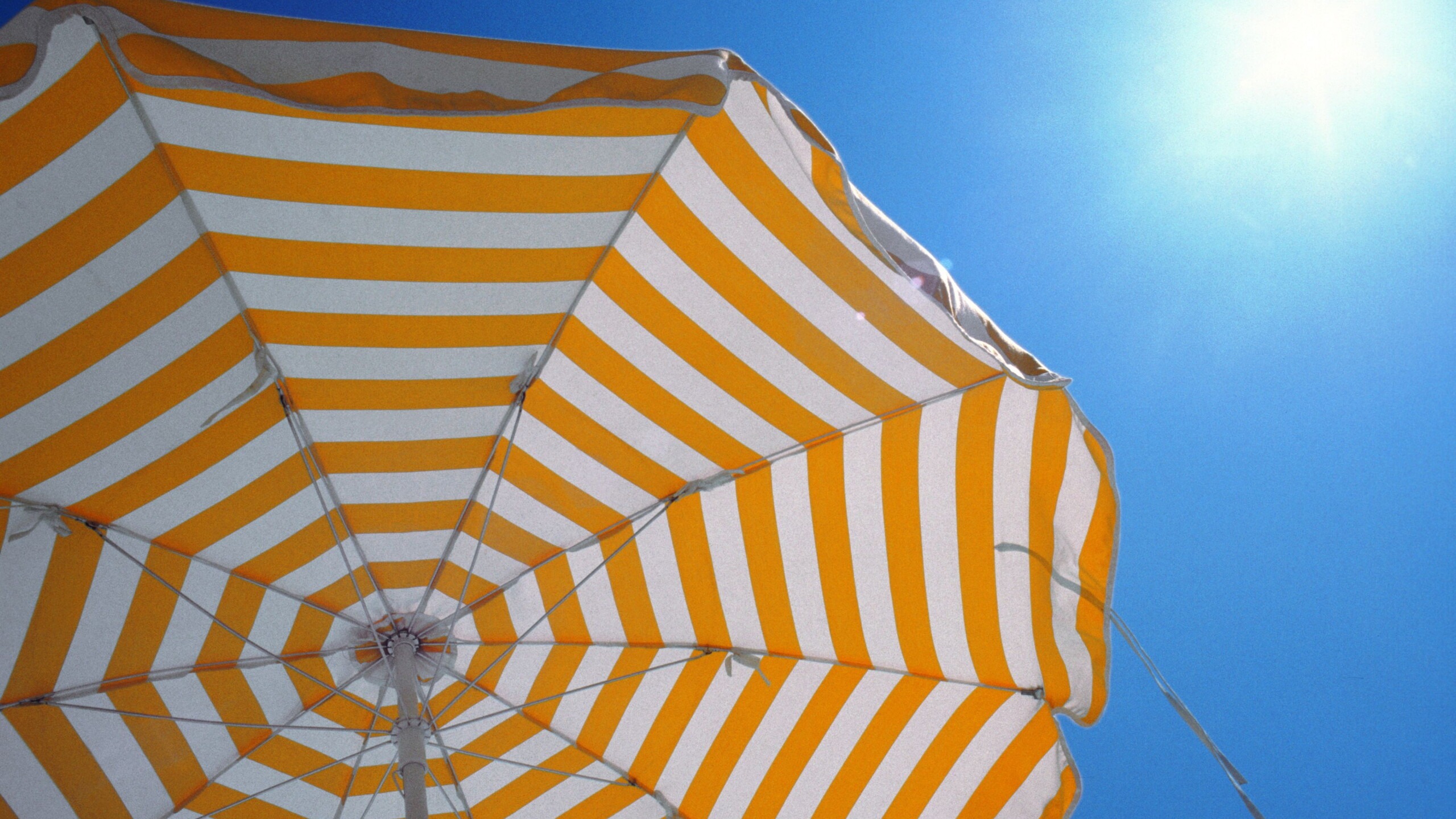 Oranje parasol met blauwe zomerse lucht