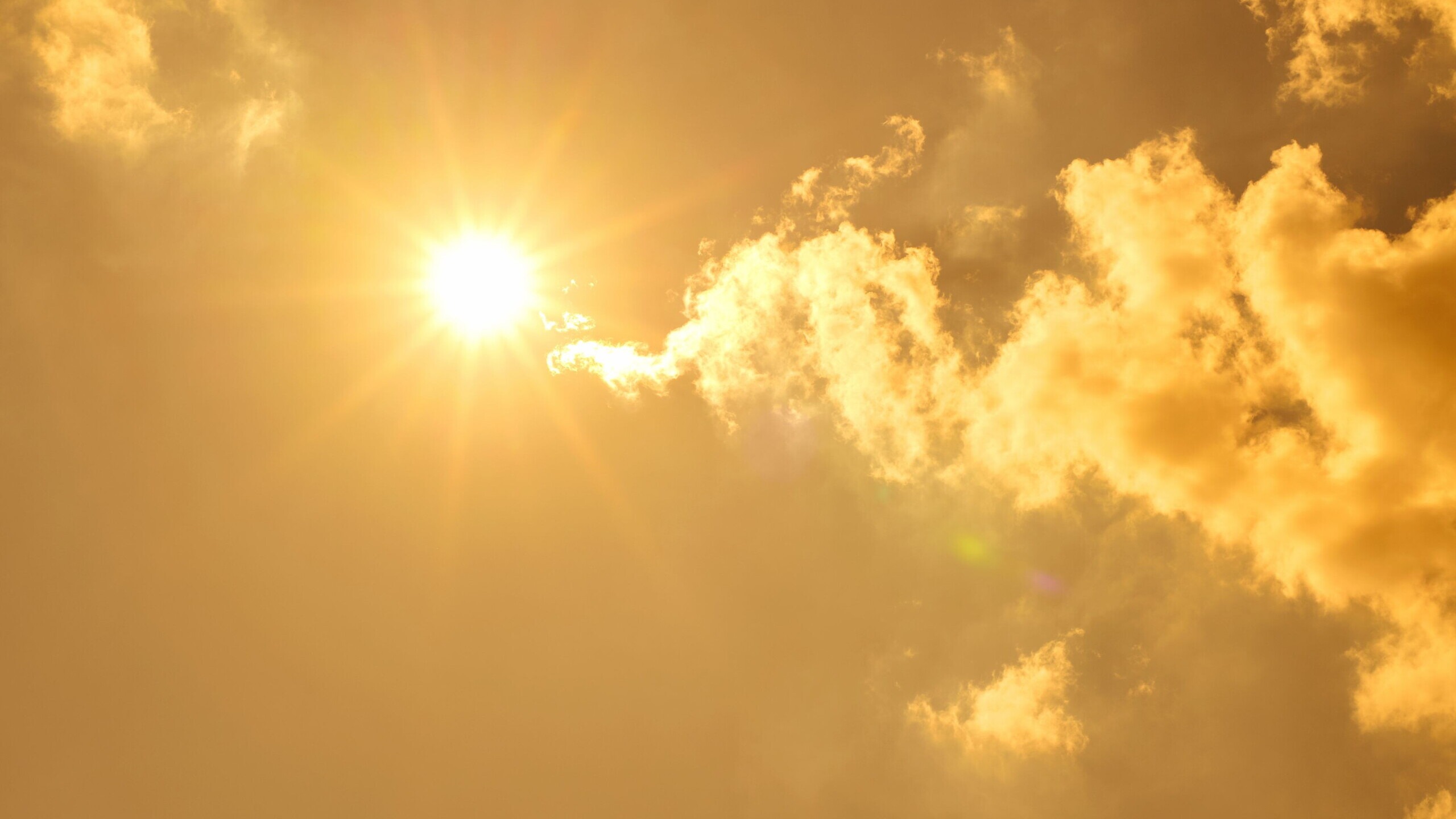 Lucht met wolken en een felle zon