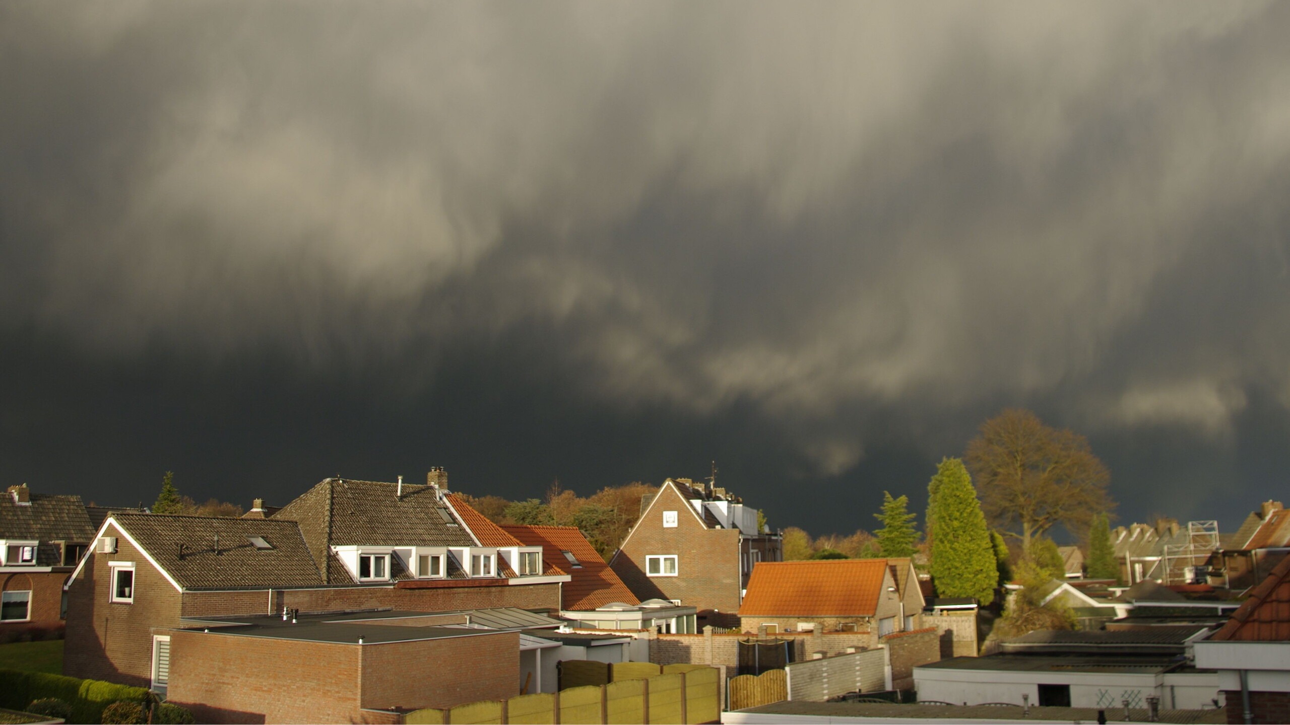 Donkere lucht boven daken in woonwijk - storm
